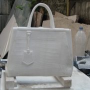 Фото скульптуры из мрамора в виде женской сумочки; фронтальный вид. Производство авторской скульптуры по приемлемой цене в Киеве. Стоимость мраморной скульптуры, согласно проекта памятника.