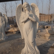 Фигура ангела из белого мрамора на производстве. Фото ангела в галерее скульптуры. Статуя ангела на кладбище.
