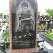 На фото, детский памятник на Южном кладбище с портретом мальчика во весь рост. Комбинированный памятник из Капустинского красного  гранита и чёрного габбро, изготовление в Киеве.