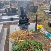 Памятник из рваного камня с женским портретом. Высота памятника - 2 м.