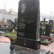 Памятник в форме обапола на двоих, фото на кладбище. Обапол из чёрного габбро с портретом. Изготовление резных памятников из обапола фото, после монтажа. Цена памятника 6 тыс. грн.