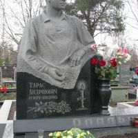 Скульптура юноши из гранита на колонне.